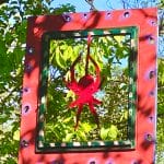 Wooden cut our spider inside frame hanging from tree branch