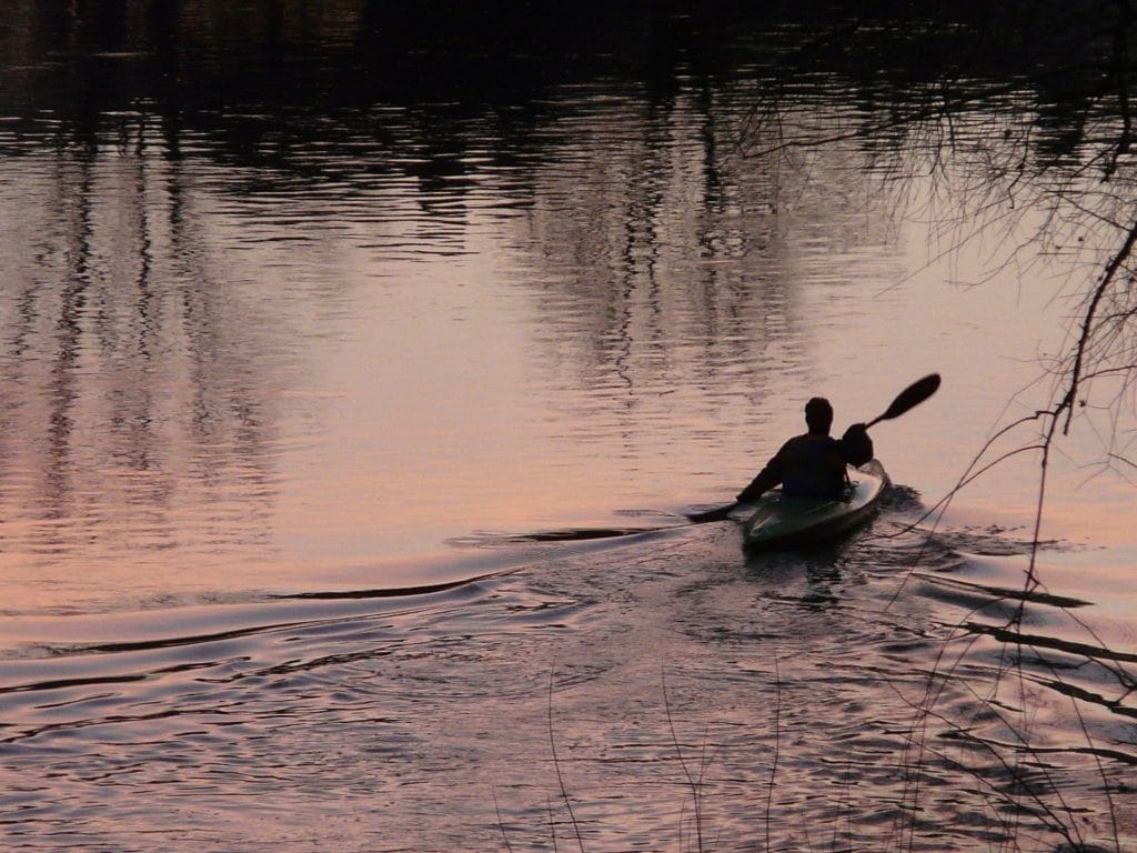 kayaker under darkened skies