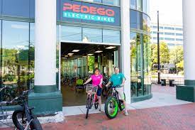 Two patrons sit on bikes out front of Pedigo Electric Bike Rentals and Tours in Portsmouth, Virginia