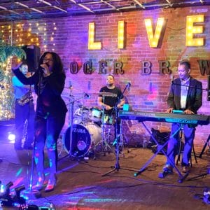A woman and band play live on a stage in Portsmouth, Virginia