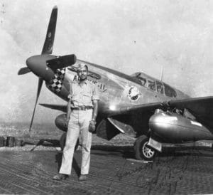 Howard L. Baugh stands in front of a plane (Black and White Image)