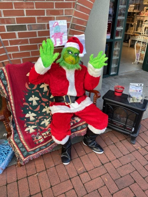 Grinch character in a Santa costume