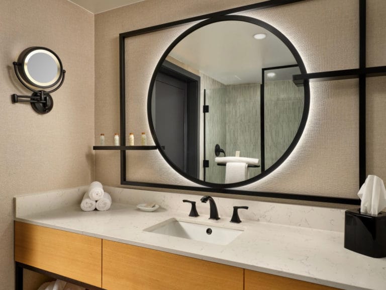 A circular lit mirror inside a Renaissance Portsmouth Norfolk guest room bathroom A circular lit mirror inside a Renaissance Portsmouth Norfolk guest room bathroom