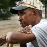 Former black baseball player Sam Allen leans on a fence