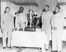 Tuskegee Airmen pose in front of a Trophy 