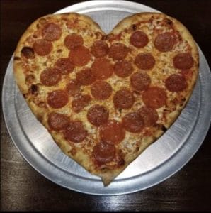 A heart-shaped pizza on a silver platter at Gino's Pizzeria in Portsmouth, Virginia