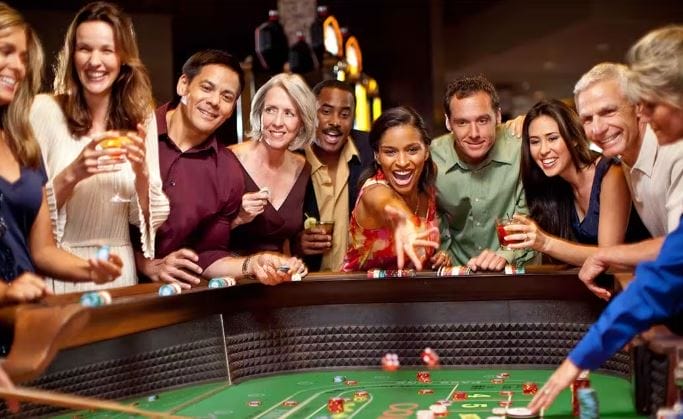 A group of people around a Craps table at Rivers Casino in Portsmouth, Virginia as a women throws in dice.