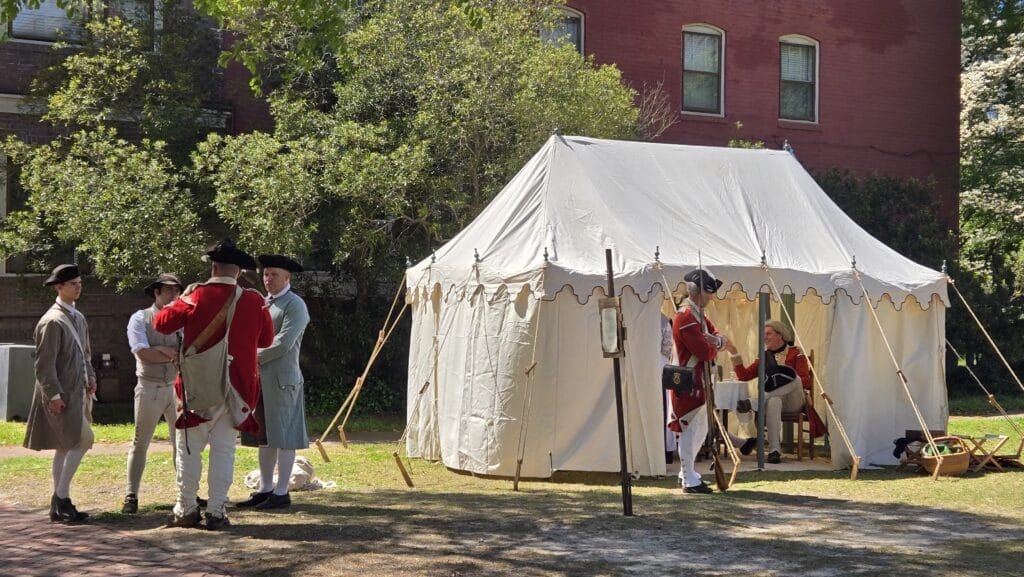 British officers inside tent with guard and other troops nearby